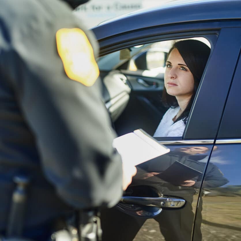 Cropped shot of an unrecognizable male traffic officer issuing a ticket to a female civilian at a roadblock