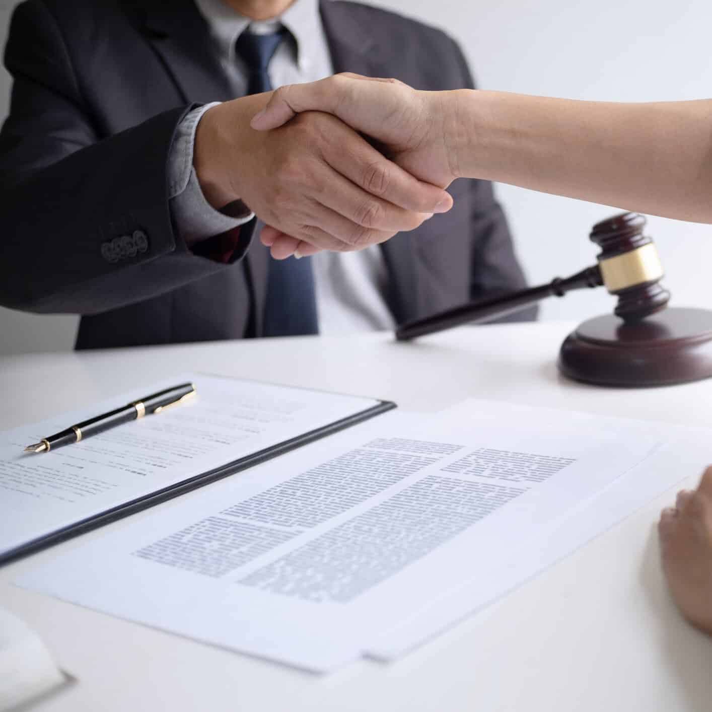 lawyer with client hands shaking in courtroom, legal and justice concept.